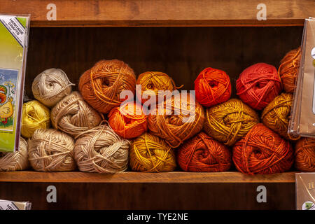 Knitting wool stacked on a shelf. Stock Photo