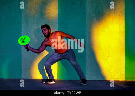 Two young men playing with a paddle and rubber ball AKA Matkot on the beach. Photographed on the beach, Tel Aviv, Israel at sunset Stock Photo