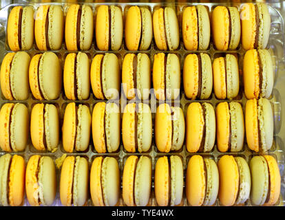 Fench macarons background close up. Tasty sweet color macarons as bakery concept. Selective focus. . Sweet macarons in plastic box for sale. Food back Stock Photo
