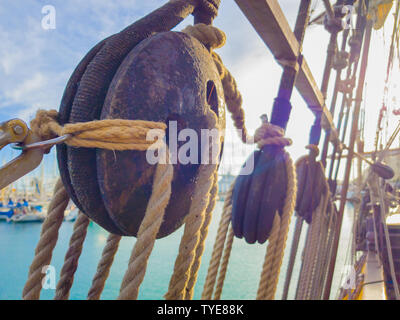 Old wooden deadeye on the shrouds of a tall ship of the eighteenth century in the sunlight. Stock Photo