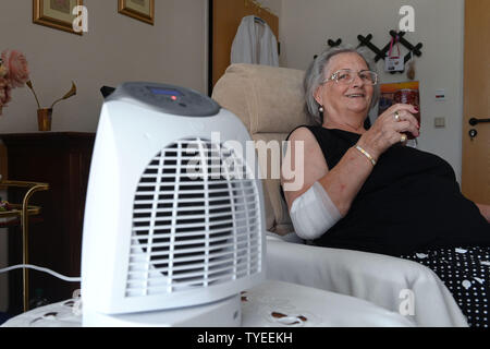 Kassel, Germany. 26th June, 2019. 76 year old Renate Stössel sits in her room in the old people's home Käthe-Richter-Haus next to a running fan with a glass of water in her hand and tries to withstand the heat. Credit: Uwe Zucchi/dpa/Alamy Live News Stock Photo