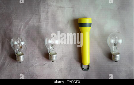 Torch light and three light bulbs in a row. Stand out from the crowd or leadership concept. Stock Photo