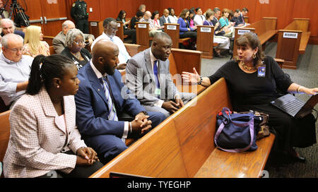 State Attorney Angela Corey (far right) talks with Tracy Martin and Sybrina Fulton (left), the parents of slain teen Trayvon Martin, and their attorney, Benjamin Crump (right) in Seminole circuit court on the second day of jury selection in Sanford, Florida,  June 11, 2013.  George Zimmerman is accused of second degree murder in the fatal shooting of Trayvon Martin.  UPI/Joe Burbank, Pool Stock Photo