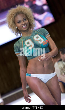 A Miami Dolphin cheerleader presents a swimsuit creation by Lila Nikole  designer during the Miami Dolphins Cheerleaders 2014 Swimsuit Calendar  Unveiling at the LIV Nightclub, Fontainebleau Hotel, Miami Beach, Florida,  September 5