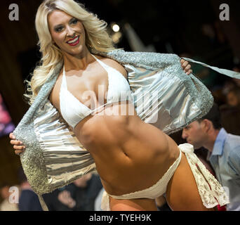 A Miami Dolphin cheerleader presents a swimsuit creation by Lila Nikole designer during the Miami Dolphins Cheerleaders 2014 Swimsuit Calendar Unveiling  at the  LIV Nightclub, Fontainebleau Hotel, Miami Beach, Florida, September 5, 2013. UPI/Gary I Rothstein. Stock Photo