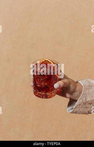 Woman helding Negroni, an italian cocktail, an apéritif, first mixed in Firenze, Italy, in 1919. Count Camillo Negroni asked to strengthen his America Stock Photo