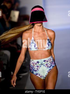 A Miami Dolphin cheerleader presents a swimsuit creation by Lila Nikole  designer during the Miami Dolphins Cheerleaders 2014 Swimsuit Calendar  Unveiling at the LIV Nightclub, Fontainebleau Hotel, Miami Beach, Florida,  September 5