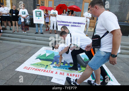 Ukrainians wearing white in t-shirts reading Support, Don't punish perform during a rally against repressive drug policies in front the Presidential Administration in Kiev.The rally was part of the global campaign 'Support, Don't punish' held in support of on the rights of drug addicted people and it was timed on the International Day against drug Abuse and Illegal Circulation and the International Day in Support of Victims of Torture, which of both are marked on 26 June. Stock Photo