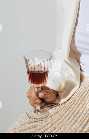 Woman helding a cup of vermouth, an italian aromatized and fortified white wine flavored with various botanicals Stock Photo