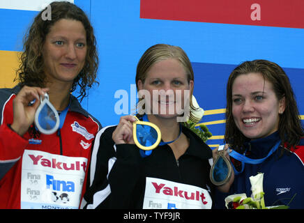 Kirsty Coventry of Zimbabwe (center) brandishes her gold medal win from the women's 100-meter backstroke final race at the XI FINA World Championships in Montreal, Canada on July 26, 2005.  Coventry, the Olympic silver medalist in the event, won the world title in a personal best time of 1:00.24 ahead of 2003 world champion Antje Buschschulte (left) of Germany and world record holder Natalie Coughlin (right) of Emeryville, CA. (UPI Photo / Grace Chiu) Stock Photo