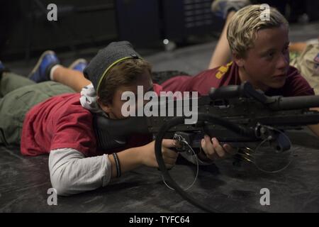 Noah Allen, Boy Scout, Troop 377, fires a M249 Squad Automatic Weapon at the Indoor Simulated Marksmanship Trainer aboard Marine Corps Air Ground Combat Center, Twentynine Palms, Calif., Nov. 5, 2016, during the Boy Scout Camp Out for local Boy Scouts of America troops. Stock Photo