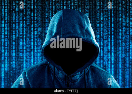 Anonymous hooded computer hacker portrait on computer code background Stock Photo