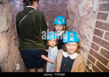 Mother / mum and children kids in Exeter's underground passages and tunnels, interesting destination for family tour of these ancient cut and cover tunnel network. Exeter. UK (109) Stock Photo