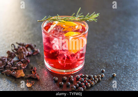 Beautiful hibiscus kombucha cocktail with gin and vodka, decorated with rosemary branch. Stock Photo