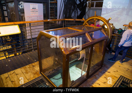 Children & interactive ships wheel display / ship steering simulator exhibit at / inside The Dockyard Museum at Brunel's SS Great Britain in Bristol. UK. (109) Stock Photo