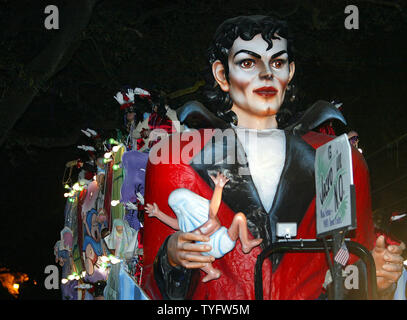 A float in the Muses parade spoofing the baby-dangling Michael Jackson rolls down St. Charles Avenue in New Orleans  February 18, 2004. The irreverent women of Muses  have become a crowd favorite in a few short years, thanks to their secret-until-parade-time themes and plentiful, innovative throws. This year, the 660 women rode on 25 floats.  (UPI / A.J. Sisco) Stock Photo