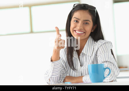 Portrait of an Indian businesswoman pointing and smiling Stock Photo