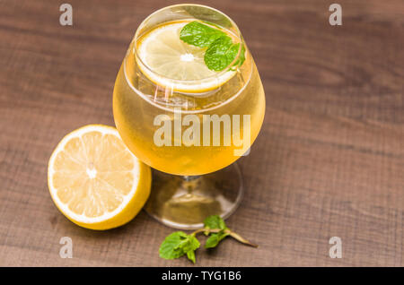 Beautiful kombucha cocktail of honey, ginger and lemon with vodka, decorated with mint leaf. Stock Photo