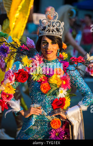 NEW YORK CITY - JUNE 25, 2017: A transgender drag performer wearing flowers with her beauty queen tiara passes in the annual gay pride parade. Stock Photo