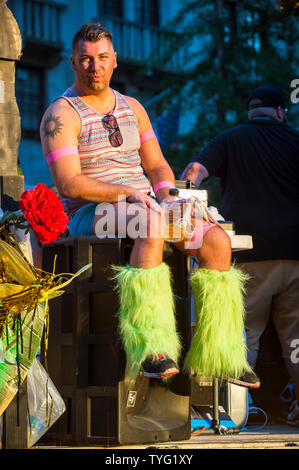NEW YORK CITY - JUNE 25, 2017: A man wearing a pair of camp furry green leg warmers sits on a float in the Gay Pride Parade in Greenwich Village. Stock Photo