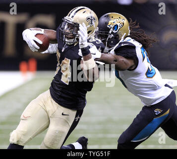 New Orleans Saints running back Travaris Cadet (38) is tripped up by  Jacksonville Jaguars strong safety Johnathan Cyprien (37) in the first half  of an NFL football game in New Orleans, Sunday