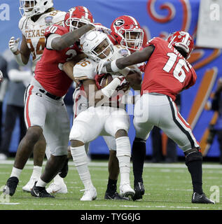 Texas Longhorns running back Keaontay Ingram (26) is stopped behind the  line by Oklahoma defensive lineman Kenneth Mann (55) during the Dr. Pepper  Big-12 Championship between the Oklahoma Sooners vs Texas Longhorns