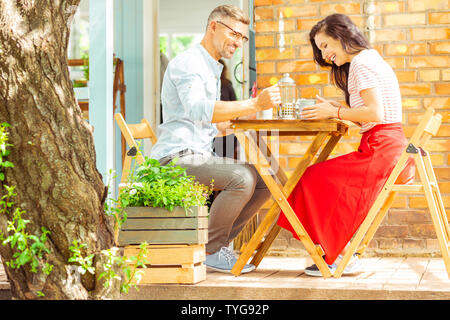 Happy couple laughing on their date in a cafe. Stock Photo