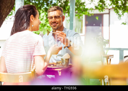 Happy married couple having lunch at summer cafe. Stock Photo