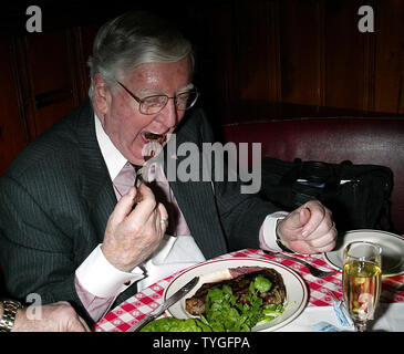 Michael Gillespie, a real estate developer from Manhattan, eats the 5 millionth steak served at Gallagher's Steak House in New York on January 14, 2004.  Gillespie is a regular at Gallagher's, dining at the restaurant weekly for the past 40 years.  He received a bottle of Dom Perignon champagne with his lunch and will receive an annual dinner for two at Gallagher's for the next 76 years (in honor of the restaurant's 76 years in business). Stock Photo