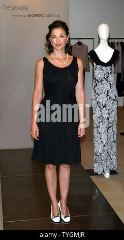 Ashley Judd poses for pictures at the unveiling of Armani fashions