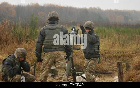 YAVORIV, Ukraine—A Ukrainian Soldier assigned to 1st Battalion, 80th Airmobile Brigade loads a 120mm round into a mortar system, Nov. 9, before a direct lay training, live-fire exercise at the International Peacekeeping and Security Center. The training exercise was observed/controlled by Soldiers assigned to 6th Squadron, 8th Cavalry Regiment, 2nd Infantry Brigade Combat Team, 3rd Infantry Division, along with Polish and Ukrainian instructors, as part of the Joint Multinational Training Group-Ukraine. JMTG-U’s mission is aimed at developing defensive skills and improving Ukraine’s capacity fo Stock Photo