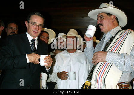 Colombian President Alvaro Uribe (L) and Juan Valdez (right), the icon of Colombian coffee, toast with coffee cups at the opening of the Juan Valdez Cafe in New York in New York on September 28, 2004.  (UPI Photo/Laura Cavanaugh) Stock Photo