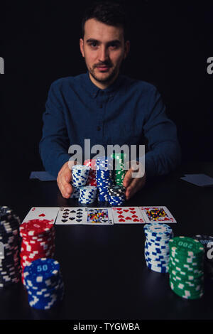Poker player going all in pushing his chips forward Stock Photo - Alamy