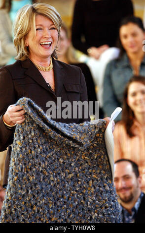 Martha Stewart holds up a poncho that was crocheted and given to her by a fellow inmate at Alderson federal prison when Martha left on 3/4/05. Martha showed it to her employees at a staff meeting held at the New York corporate offices of Martha Stewart Living Omnimedia to welcome her back after five months in prison.  (UPI Photo/Ezio Petersen) Stock Photo