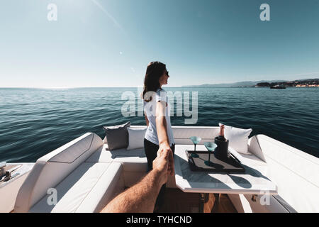 woman holding man's hand on luxury yacht on the sea Stock Photo