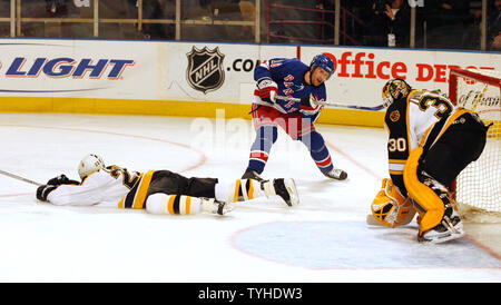 New York Rangers (18) Dominic Moore shoots while Boston Bruins (22) Brian Leetch lands on the ground  at Madison Square Garden in New York City on March 20, 2006.  The New York Rangers defeated th Boston Bruins 5-2.   (UPI Photo/John Angelillo) Stock Photo