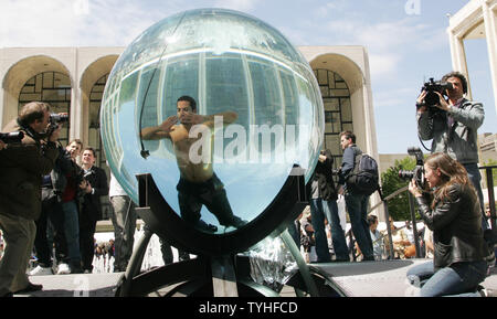 Magician and performance artist David Blaine is photographed by the media as he begins his seven-day stay in a water tank situated outside at the Lincoln Center for the Performing Arts in New York City on May 1, 2006. Blaine will breath through an air tube as he floats around in the eight-foot acrylic sphere in full public view. (UPI Photo/Monika Graff) Stock Photo