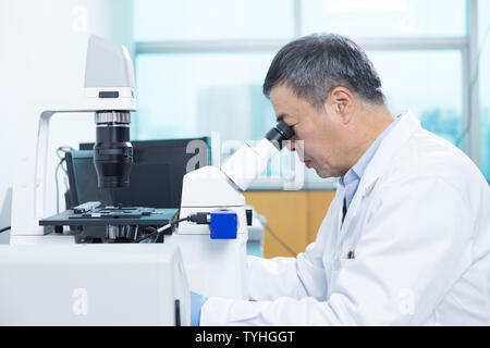 old man does medical photography in lab Stock Photo