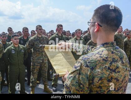 CHINA SEA (Nov. 10, 2016) Capt. Jonathan Shih, assigned to the 11th Marine Expeditionary Unit (MEU), reads the Marine Corps birthday letter during the 241st Marine Corps birthday celebration on the flight deck aboard the amphibious assault ship USS Makin Island (LHD 8). Makin Island, the flagship of the Makin Island Amphibious Ready Group, is operating in the U.S. 7th Fleet area of operations with the embarked 11th MEU in support of security and stability in the Indo-Asia-Pacific region. Stock Photo