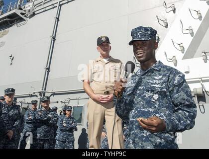 DIEGO (Nov. 10, 2016) Master Chief Petty Officer of the Navy (MCPON) Steven Giordano listens as Seaman Oladunni Ahmed asks a question during an all hands call on the flight deck of amphibious assault ship USS Boxer (LHD 4). Boxer is currently pier side preparing for a planned maintenance availability. Stock Photo