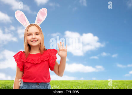 happy girl wearing easter bunny ears waving hand Stock Photo
