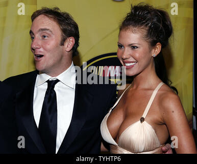 Jay Mohr and wife Nikki Cox smile at each other on the red carpet