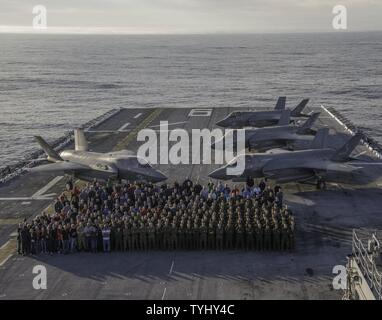 PACIFIC OCEAN (NOV. 11, 2016) Group photo of F-35B Lightning II personnel conducting short takeoff/vertical landing (STOVL) operations aboard USS America (LHA 6) during the third and final developmental test phase (DT-III) of F-35B carrier suitability and integration. A highly diverse cadre of Pax River Integrated Test Force (ITF) technicians, maintainers, engineers, logisticians, support staff, and test pilots from the Salty Dogs of Air Test & Evaluation Squadron (VX) 23 assigned to NAS Patuxent River, Maryland, are aboard USS America with Marine Operational Test and Evaluation Squadron (VMX) Stock Photo