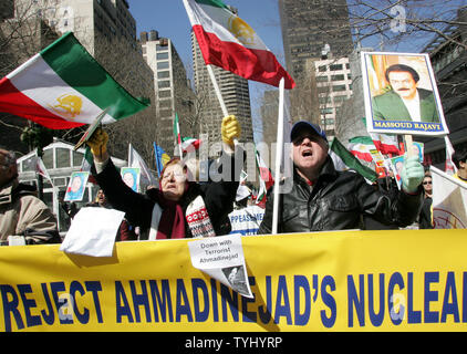 Maan Soureh (L) of Washington,DC, waves an Iranian flag as Teimour Nazari (R) of Montreal, holds a sign of Massoud Rajavi, chairman of the National Council of Resistance of Iran as they take part in the demonstration against Iran's president Mahmoud Ahmadinejad during a rally held near the United Nations on March 21, 2007 in New York City. Demonstrators, who oppose Iran's nuclear and human-rights policies, are calling for the UN to impose sanctions against Tehran.   (UPI Photo/Monika Graff) Stock Photo