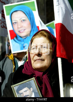 Maan Soureh, of Washington,DC, listens to a speaker as a photo of Maryam Rajavi (L) president of the National Council of Resistance of Iran, is seen during the demonstration against Iran's president Mahmoud Ahmadinejad during a rally held near the United Nations on March 21, 2007 in New York City. Demonstrators, who oppose Iran's nuclear and human-rights policies, are calling for the UN to impose sanctions against Tehran.   (UPI Photo/Monika Graff) Stock Photo