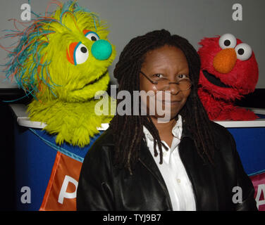 Actress Whoopi Goldberg poses with the new muppet Azibo (L) and Elmo (R) after a news conference to announce 'Panwapa', a new world wide  initiative from Sesame Street Workshop to cultivate the next generation of globally responsible children, at the United Nations International School in New York on October 10, 2007.  (UPI Photo/Ezio Petersen) Stock Photo
