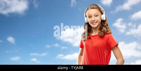 happy teenage girl in headphones over sky Stock Photo