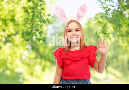 happy girl wearing easter bunny ears waving hand Stock Photo