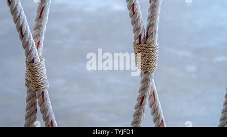 Rope knot on beach as strong nauctical marine line tied together as symbol with trust and safe traveler Stock Photo