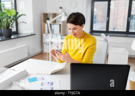 smiling ui designer using smartphone at office Stock Photo